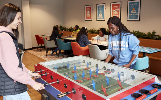 Students playing table football in communal area