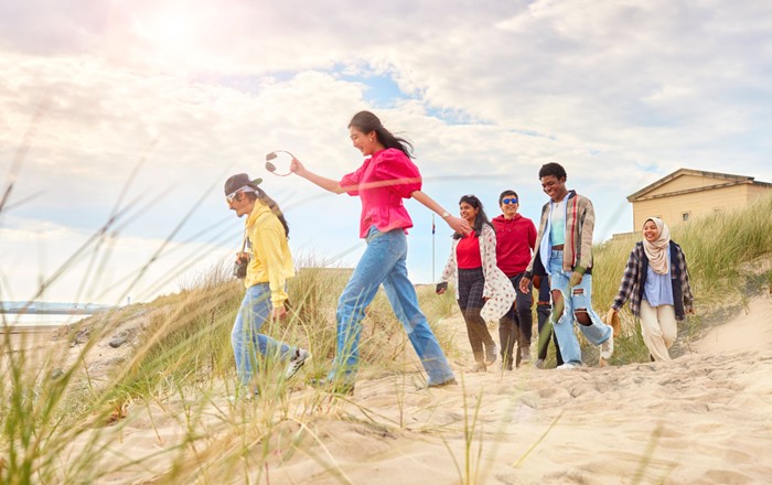 A group of students walking on a sandy beach