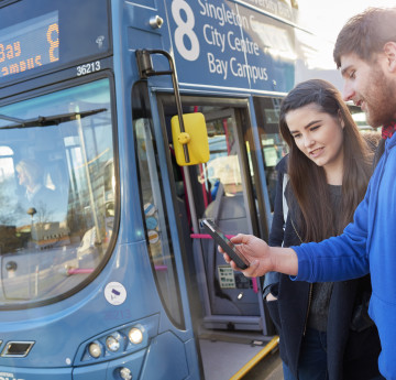 Female and male student getting on a Swansea Uni Bus