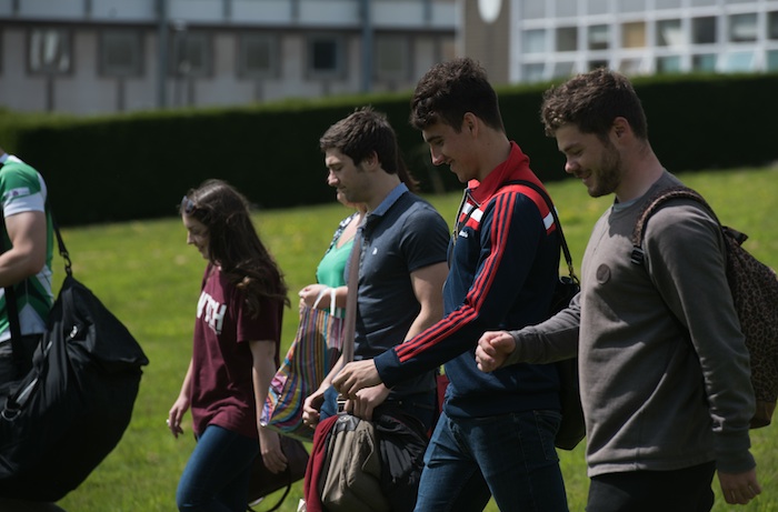 Group of students walking on the green by the Abbey on the Singelton Campus