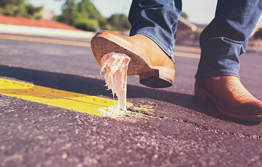 A shoe with road markings stuck to the bottom like gum