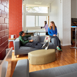 An image of two students socialising in a communal games room in accommodation on Singleton Campus.
