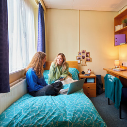 An image of two students chatting in an accommodation room.