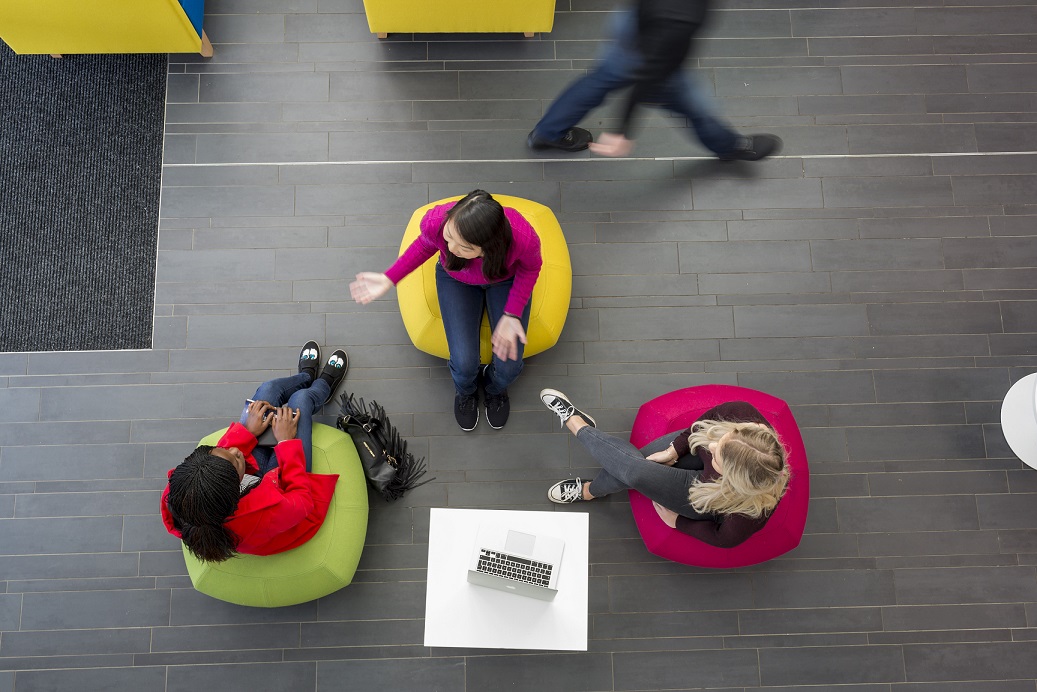 Three students sitting on bean bags 
