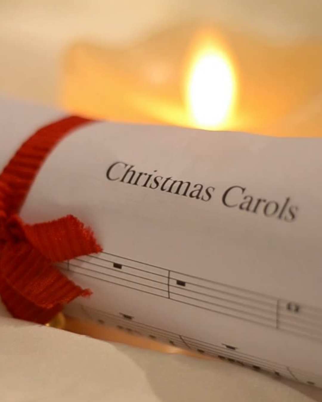 Carol sheet with candle in the background