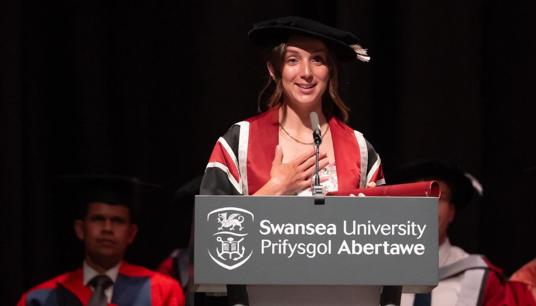 Lady standing on a lectern making a speech on stage