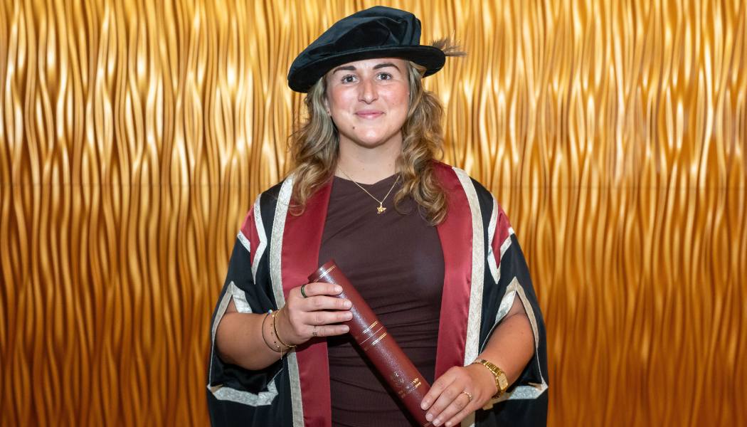 Lady wearing cap and gown and holding a scroll