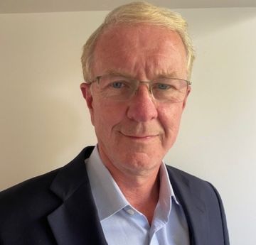 Man wearing a dark suit smiling at the camera