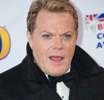 Man wearing a dicky bow and black coat looking surprised