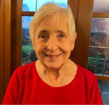 Lady wearing a red top smiling at the camera