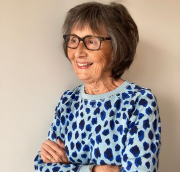 Lady in a blue dress smiling at the camera