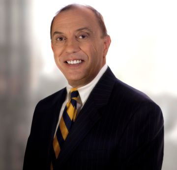 Man in a suit & tie smiling at the camera