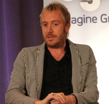 Man sitting in a chair being interviewed 