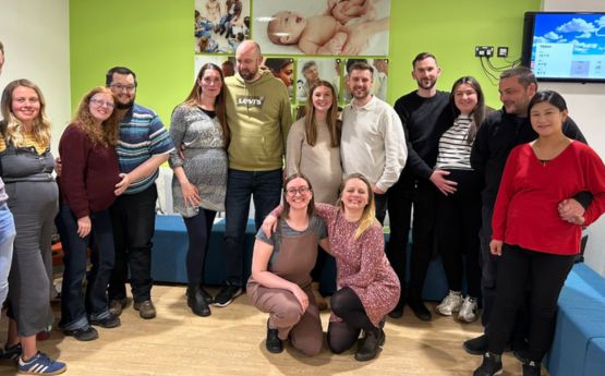 Student midwives and antenatal class participants smiling for a photo.