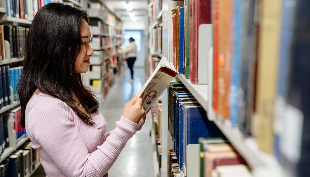Lady in the library reading a book