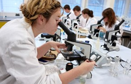 Image of a female biology researcher using a microscope in a laboratory 