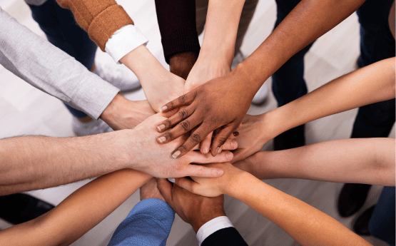 Hands of various races in a huddle 
