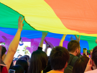 People holding up a rainbow flag
