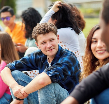 An image of a group of students sitting outdoors on Singleton Campus.