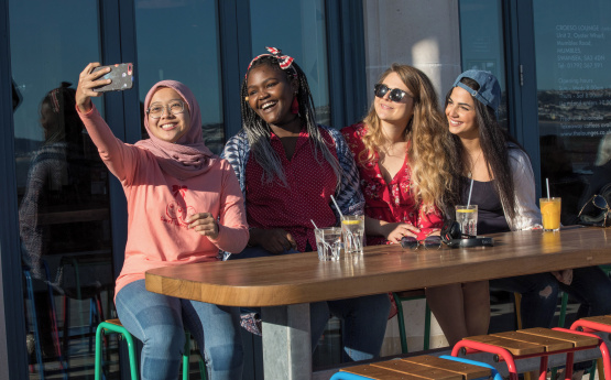 Students taking a selfie in mumbles.