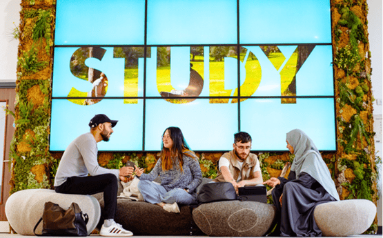 Pwedwar o myfyrwyr yn trafod ar campws. 