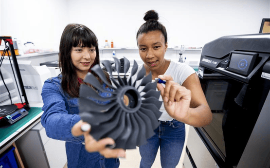 Myfyrwyr yn astudio rhan fanwl o awyren.