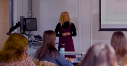 Delwedd o ddarlithydd yn addysgu mewn ystafell seminar.
