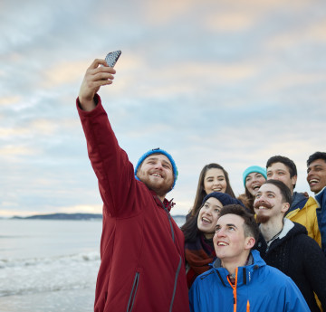 Students taking a selfie on Swansea Bay.