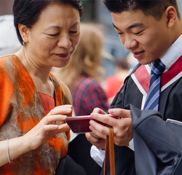Mam a mab yn edrych ar ffôn gyda'i gilydd