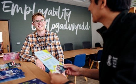 Delwedd o fyfyriwr yn siarad am opsiynau Cyflogadwyedd.