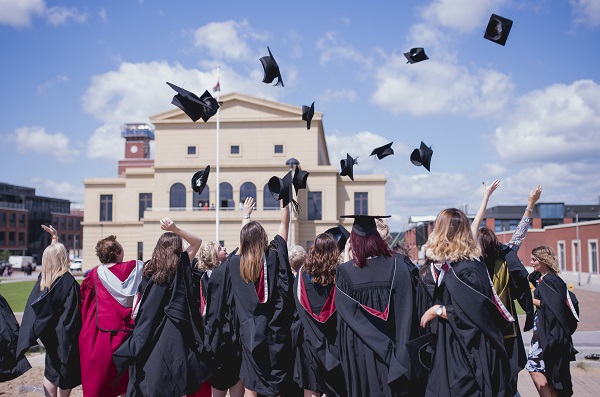 students throwing graduation caps in the air in front of the Great Hall, Bay Campus 