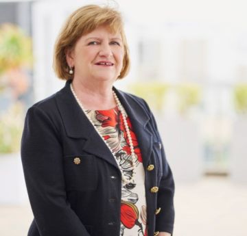 Menyw yn edrych ar y camera a gwenu