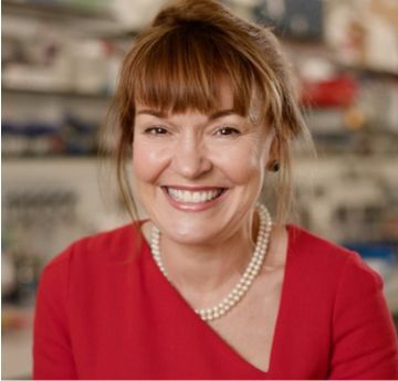 Menyw yn gwisgo gwisg coch yn gwenu i'r camera