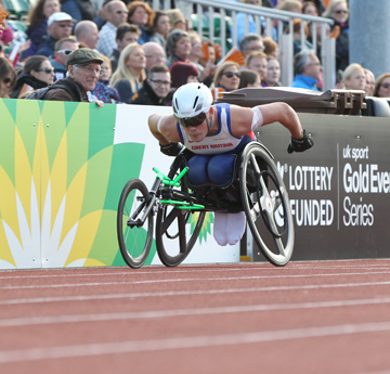 Man in wheelchair racing on athletics track