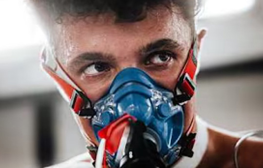 Lando Norris gyda mwgwd ocsigen ymlaen