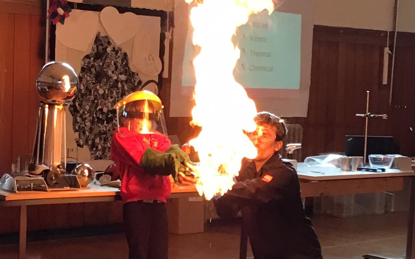 dyn yn chwythu tân ar lwyfan