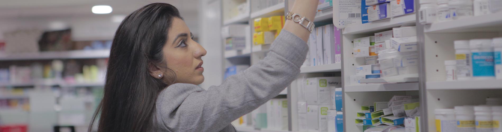 Pharmacist putting medicines on the shelf