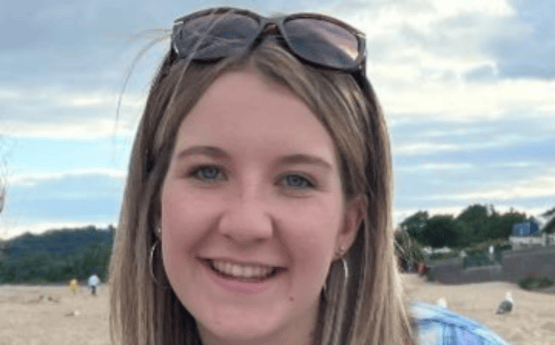 Llun o Megan Davies ar y traeth. 