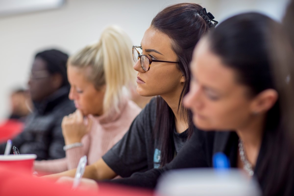 Female students sitting in a lecture theatre and listening intently.