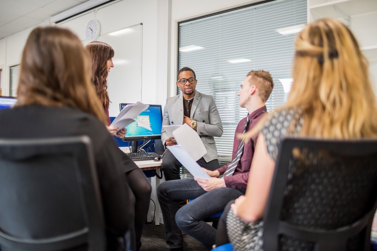 Members of staff sitting in a circle and having a meeting.