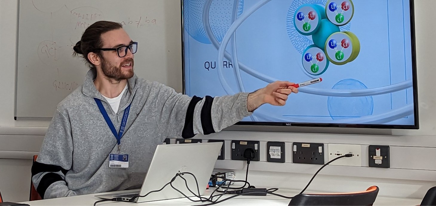 Dyn ifanc yn pwyntio at sgrin gyfrifiadur fawr yn dangos problem fathemategol