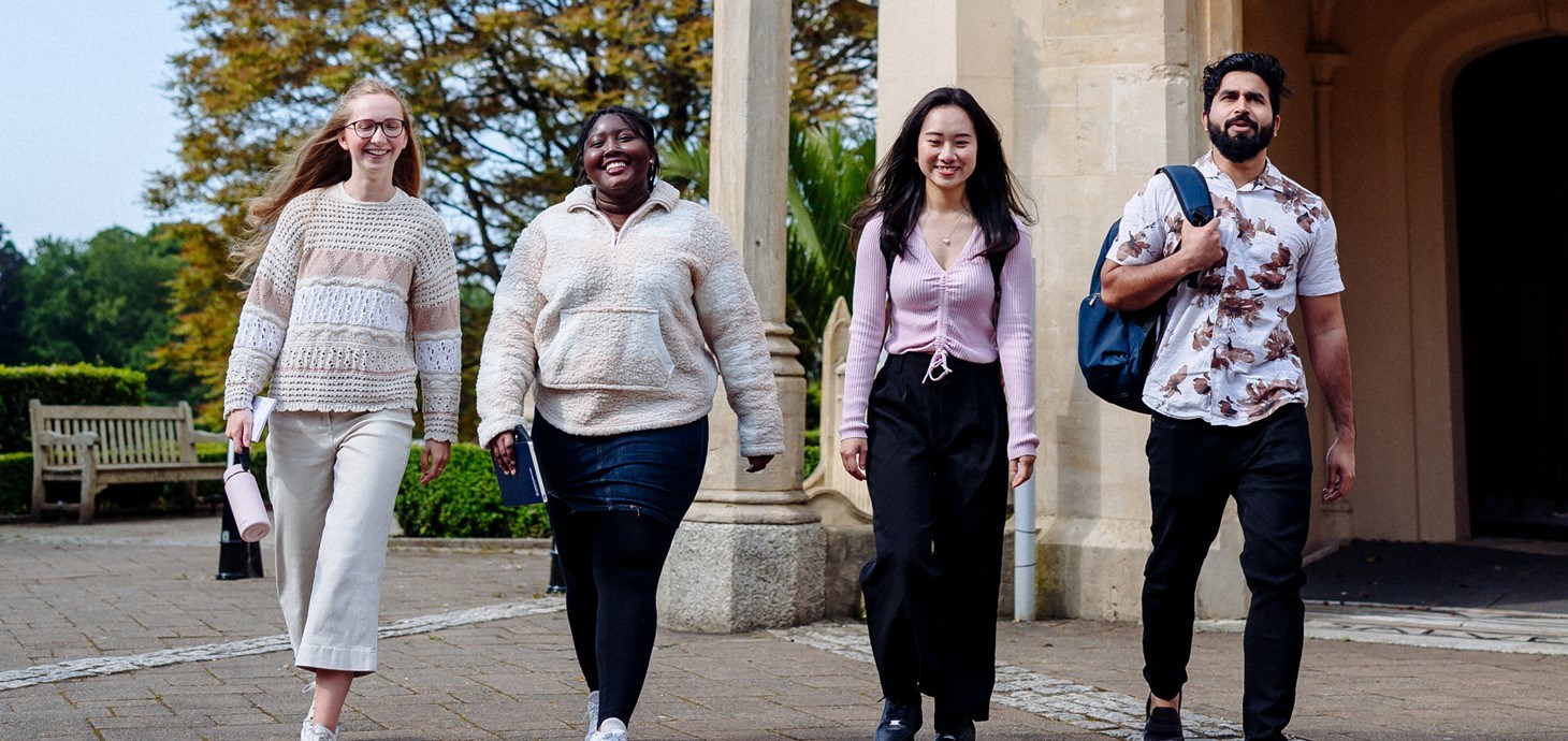 Pedwar myfyriwr yn sefyll tu allan i Abaty Singleton 