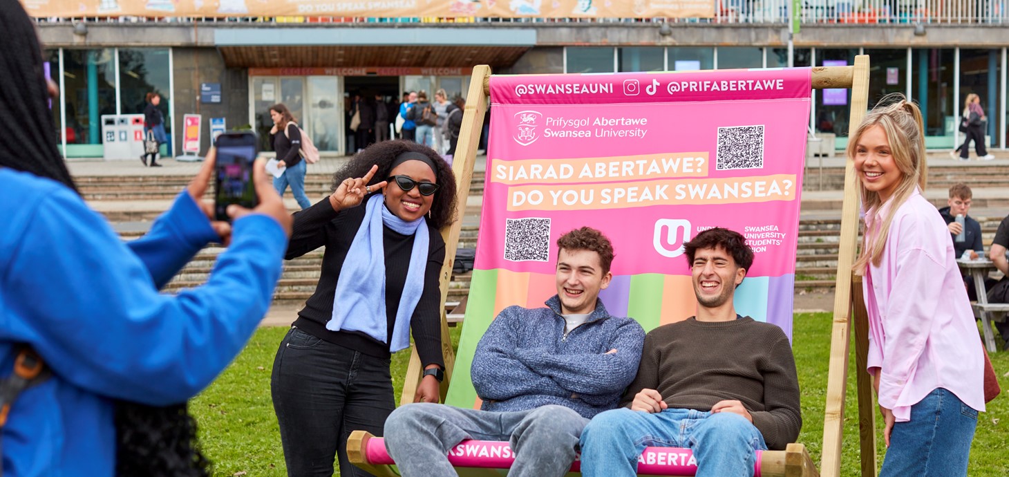 Myfyrwyr yn eistedd y tu allan i Dŷ Fulton 