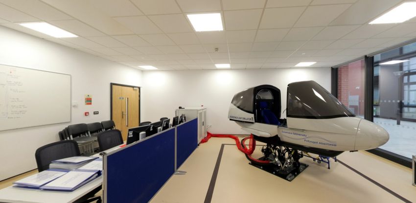 Lab efelychydd hedfan gyda cockpit, desgiau a chyfrifiaduron
