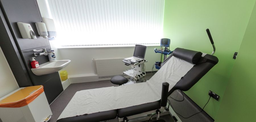 Ystafell archwilio gyda gwely meddygol, sinc ac offer diagnostig