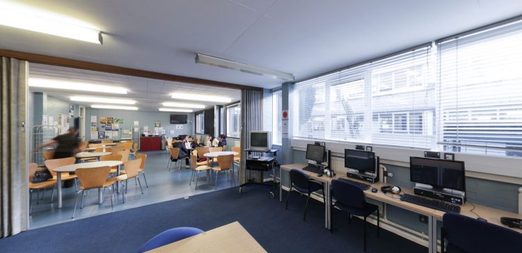 Ystafell adnoddau myfyrwyr gyda chyfrifiaduron, byrddau astudio a man eistedd