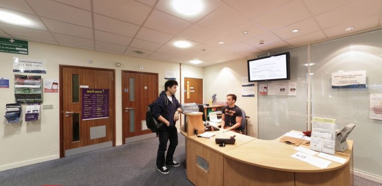 Desg dderbyn Gwasanaethau Myfyrwyr gyda aelod o staff ac ymwelydd