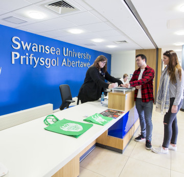 People chatting at Swansea University's reception area.