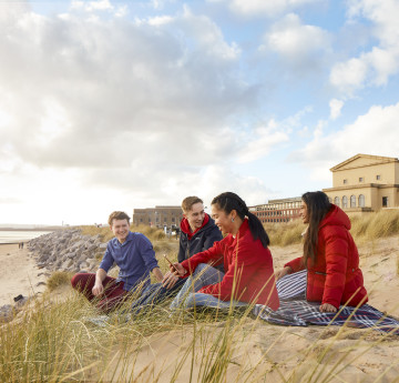 students sitting in the dunes at Crymlyn Burrows