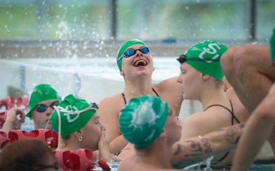 Swansea University performance swimmers celebrate at a swimming meet